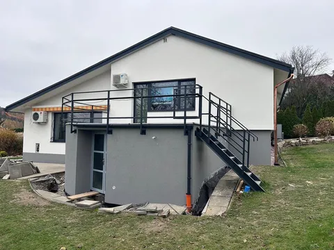 Zateplený rodinný dům s balkonem a tmavým soklem